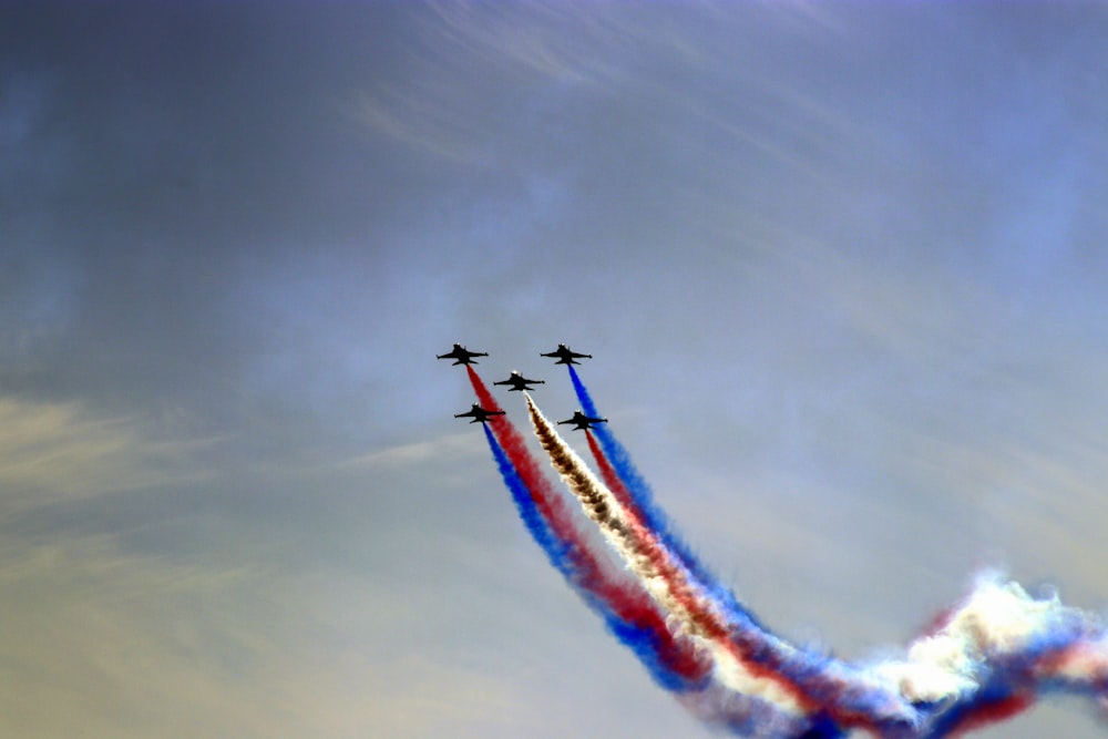 a group of jets flying through a cloudy sky