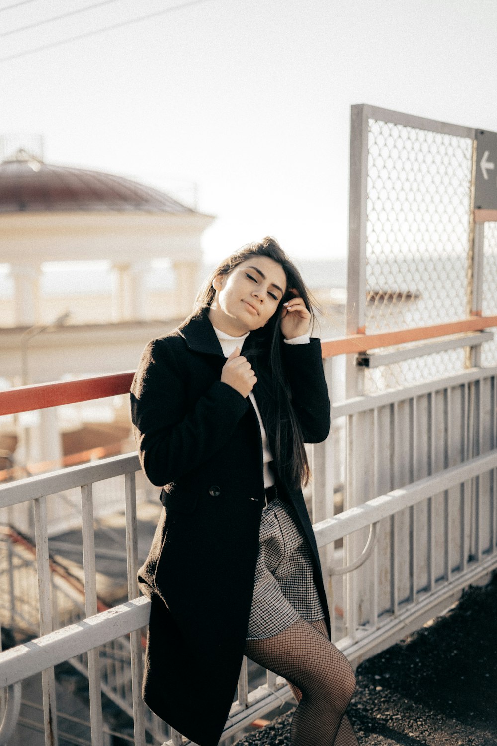 a woman standing on a bridge talking on a cell phone