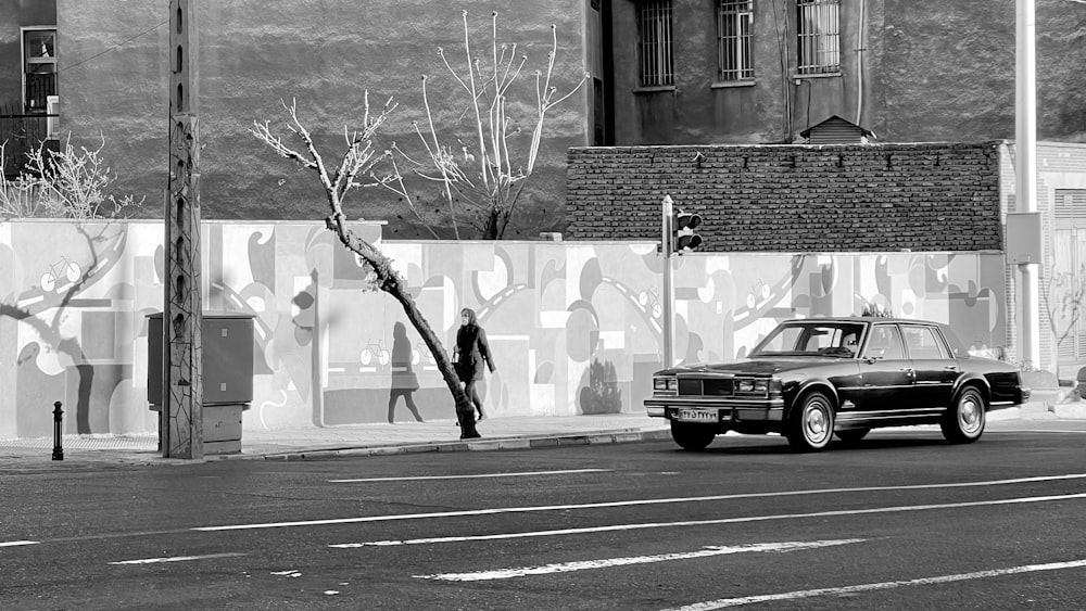 a black and white photo of a car parked on the side of the road