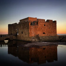 A beautifully restored Omani fortress bathed in warm sunset light, showcasing intricate stonework and traditional architecture.