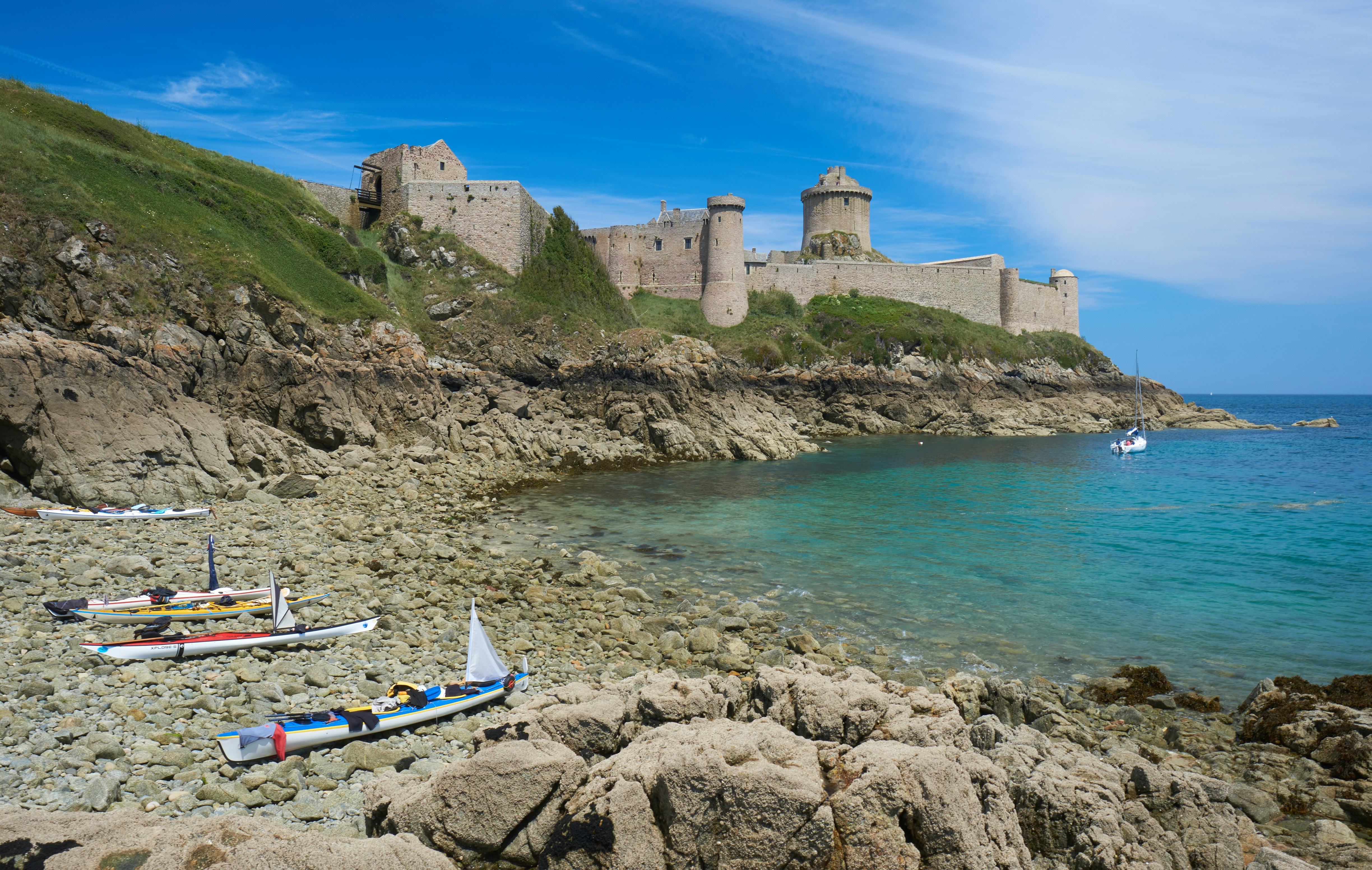 a rocky beach with a castle in the background