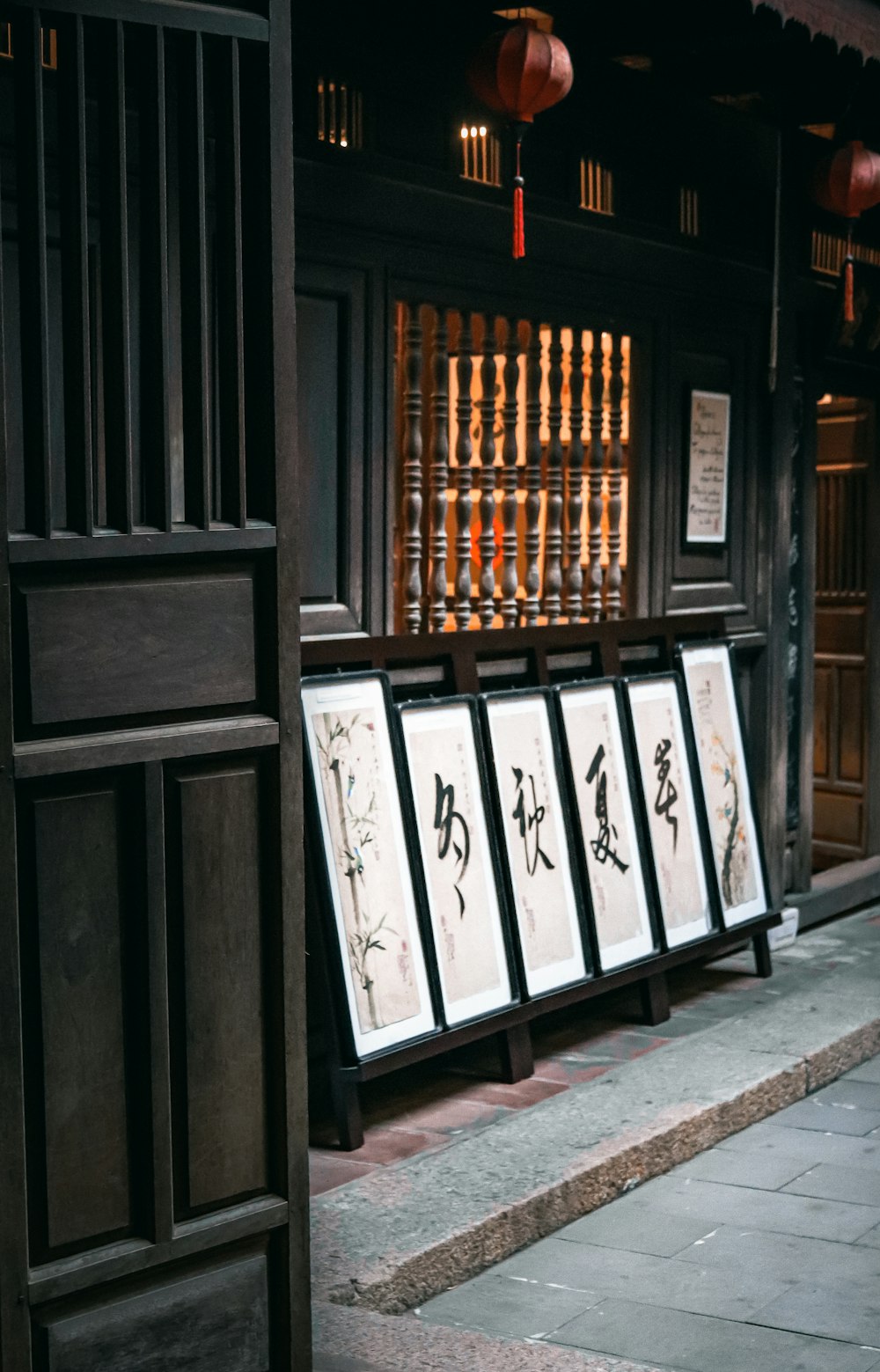 a row of framed pictures sitting on the side of a building