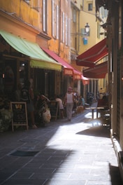 a woman walking down a street next to tall buildings