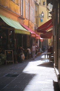 a woman walking down a street next to tall buildings