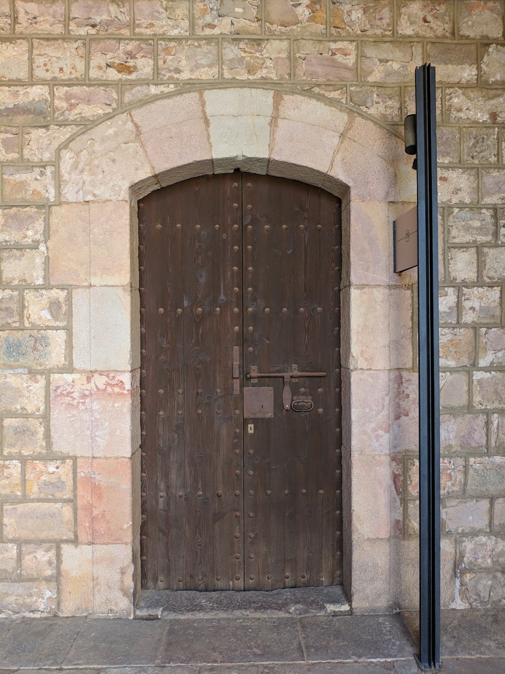 a large wooden door sitting next to a brick wall