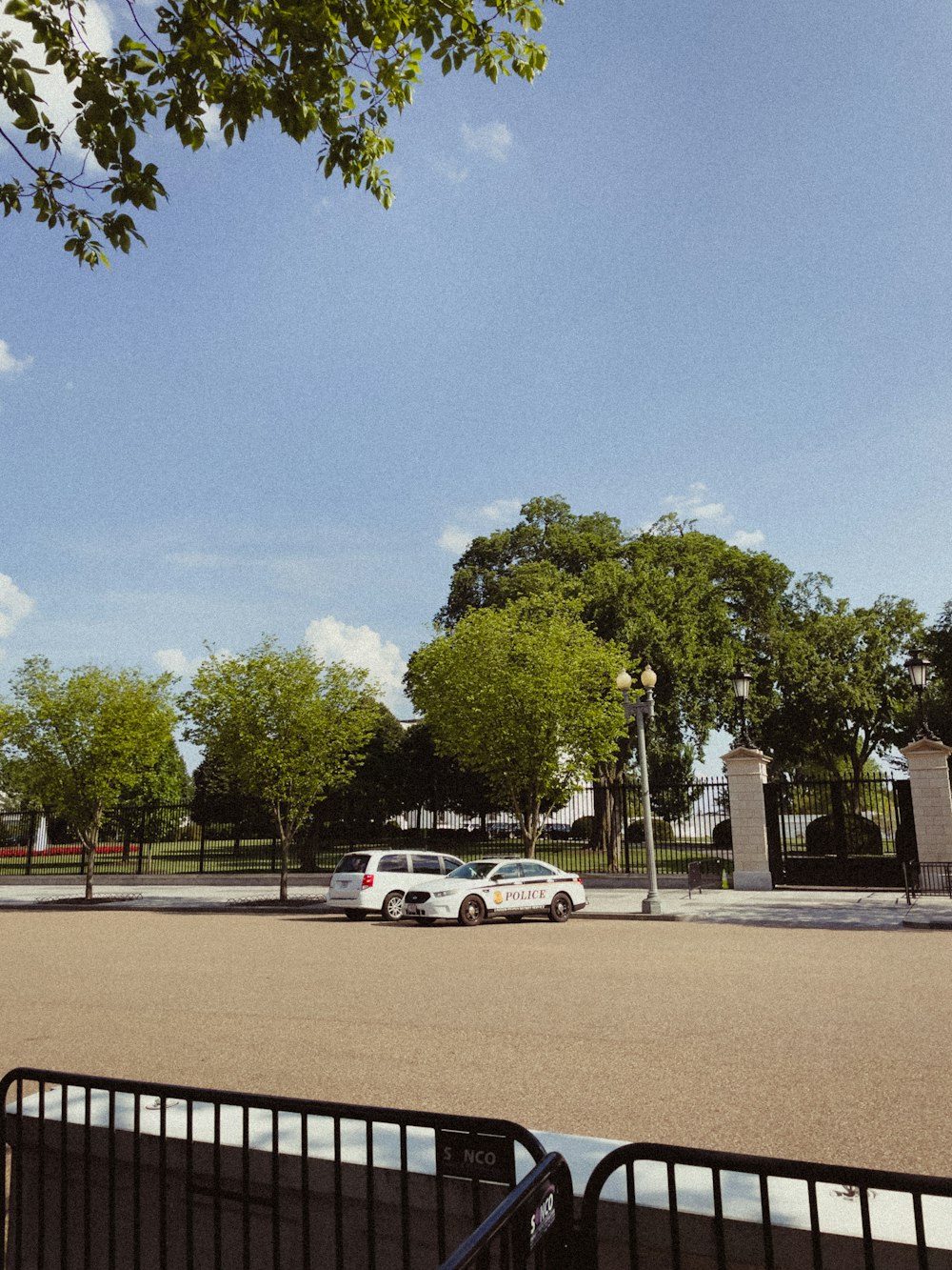 a white car parked in a parking lot next to a fence