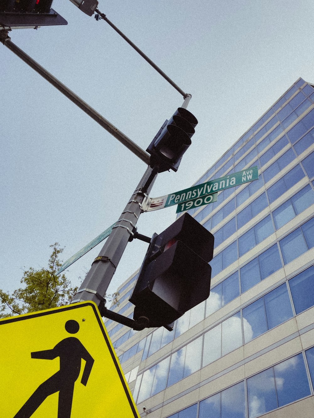 Ein Ampel- und Fußgängerüberwegschild vor einem hohen Gebäude