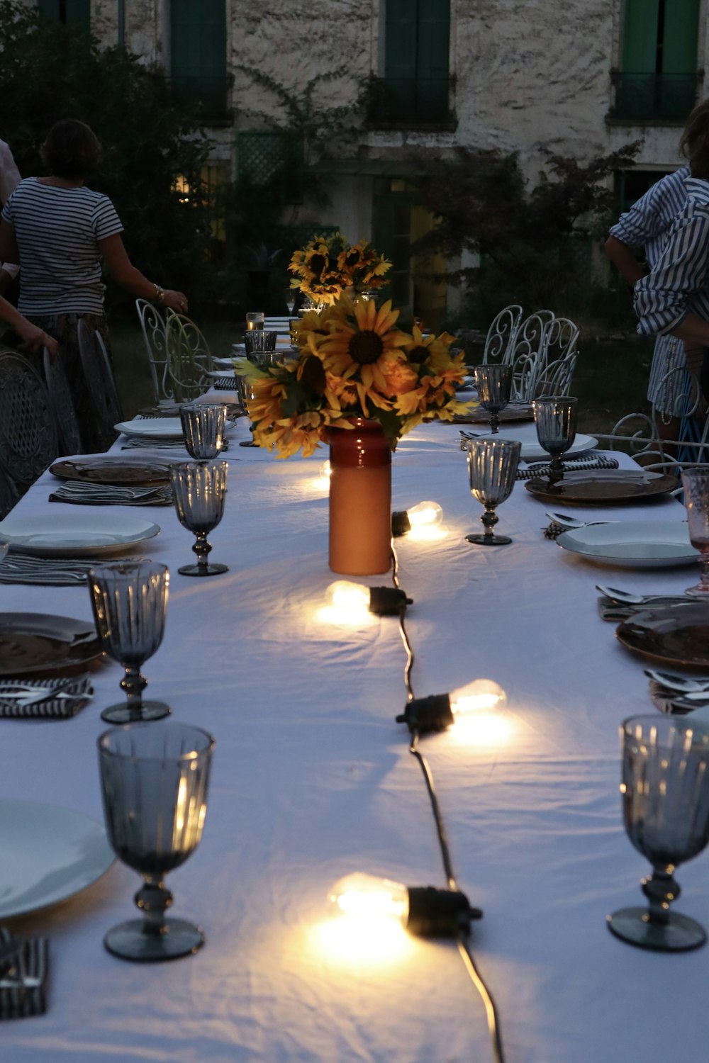 a long table with a vase of sunflowers on it