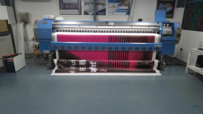 Close-up of a professional printing machine in action, showing vibrant colors on paper.