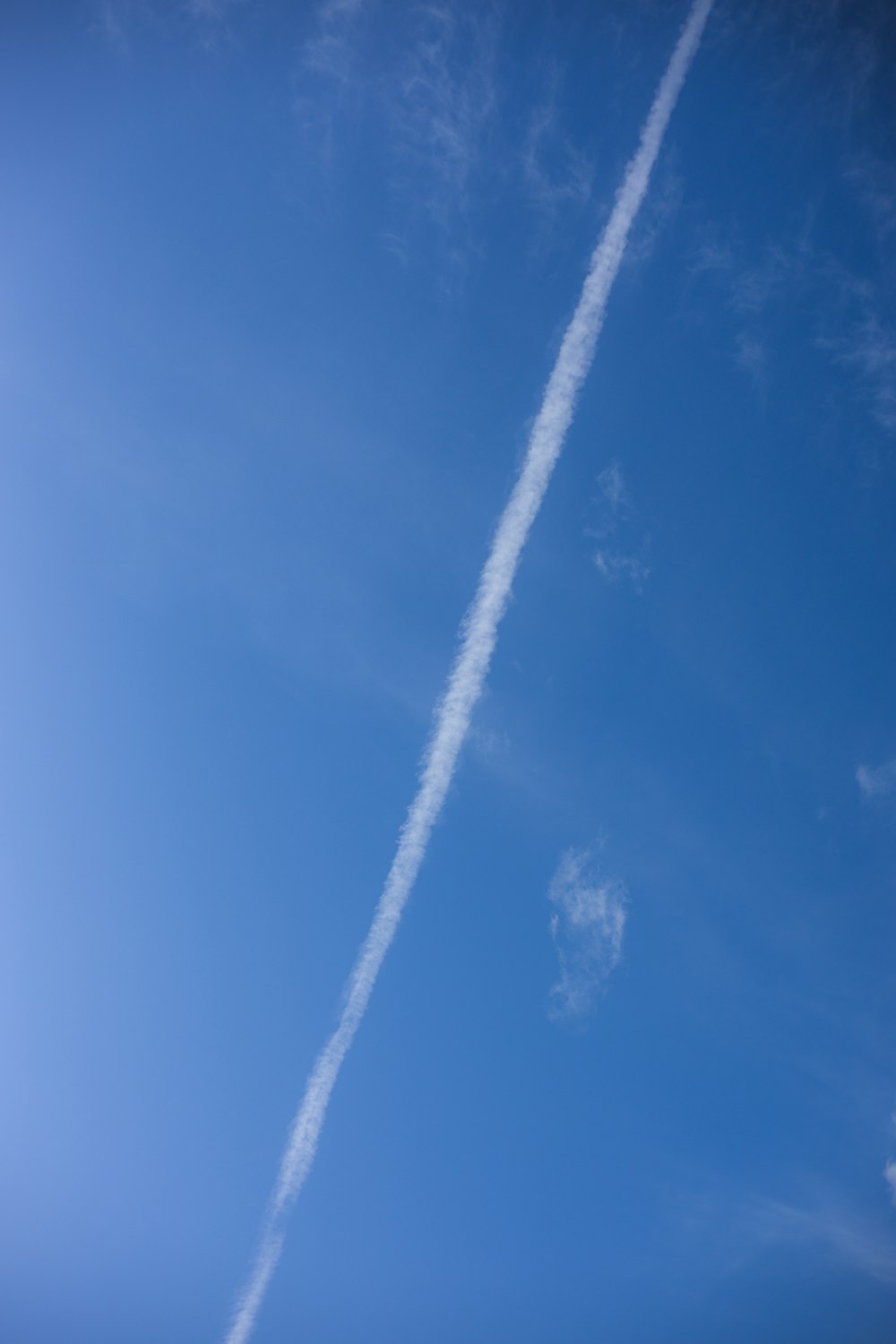 a plane flying in the sky with a contrail in the sky