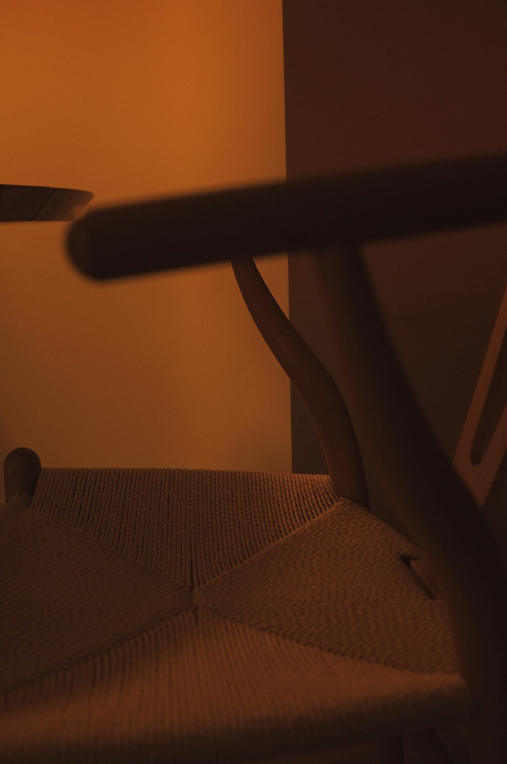 a close up of a chair with a table in the background