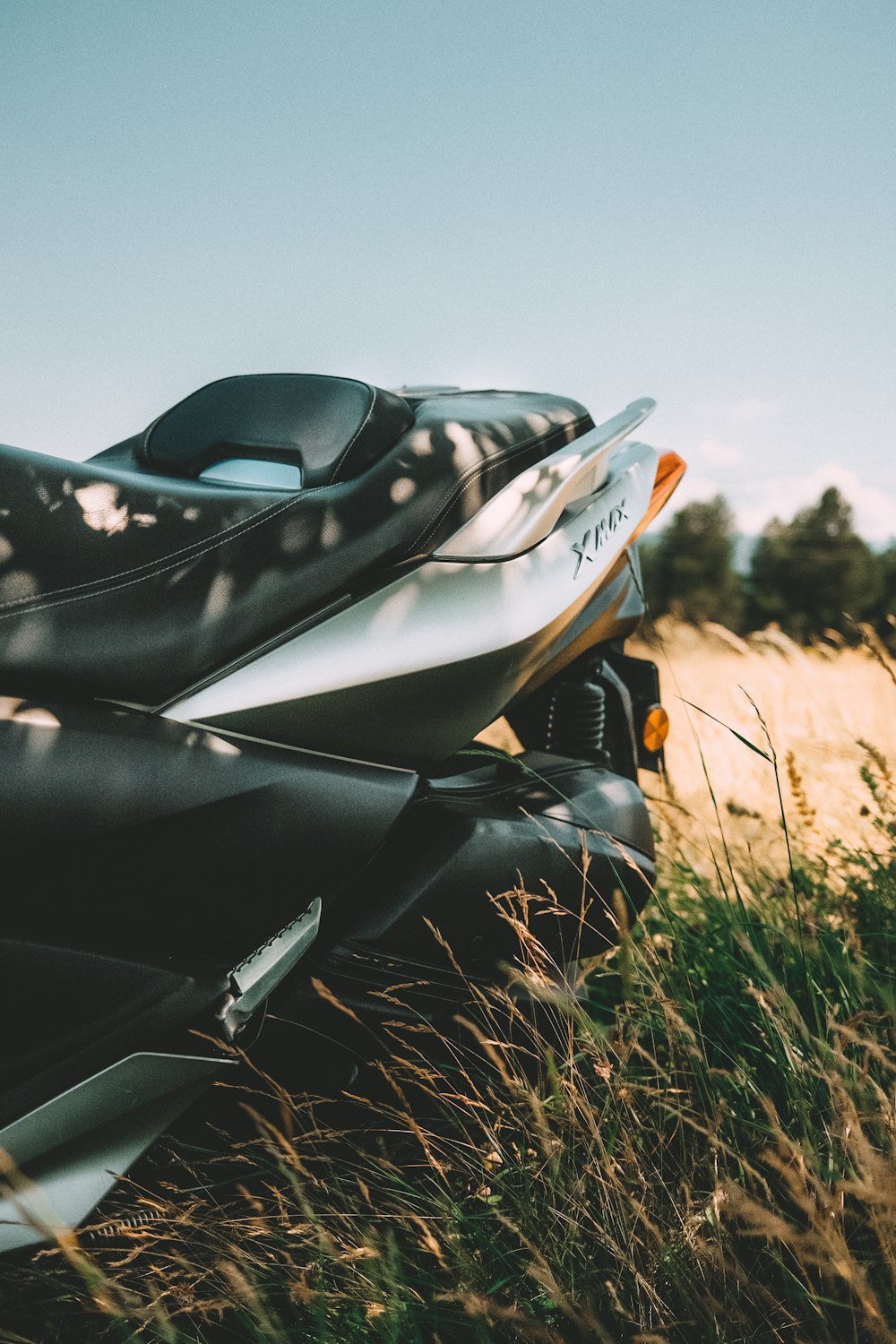 a motorcycle parked in a field of tall grass