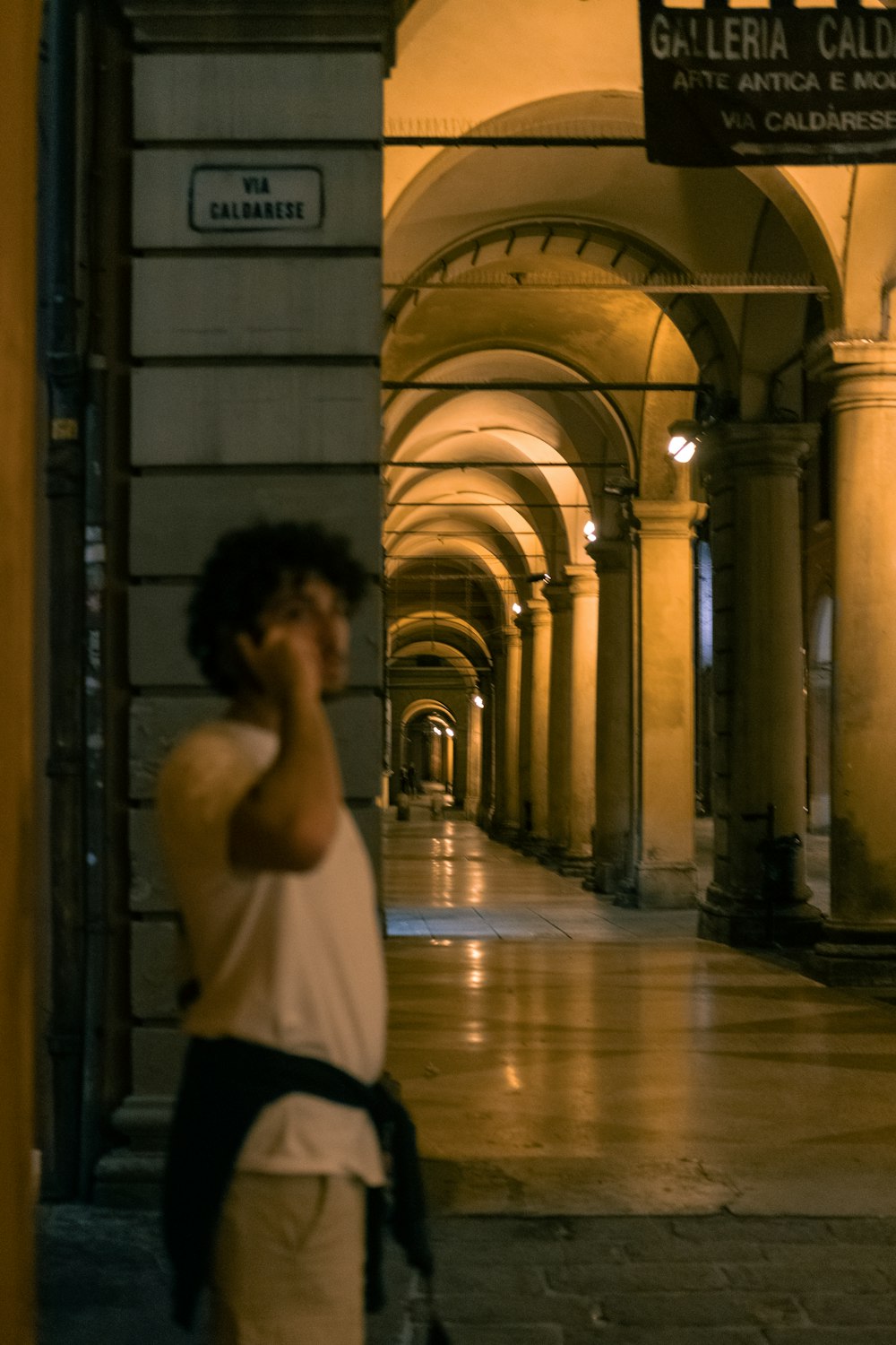 a man talking on a cell phone while walking down a hallway