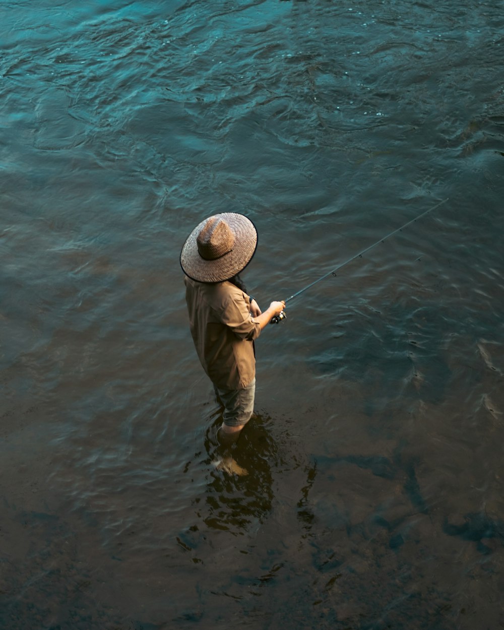 a man standing in the water holding a fishing line