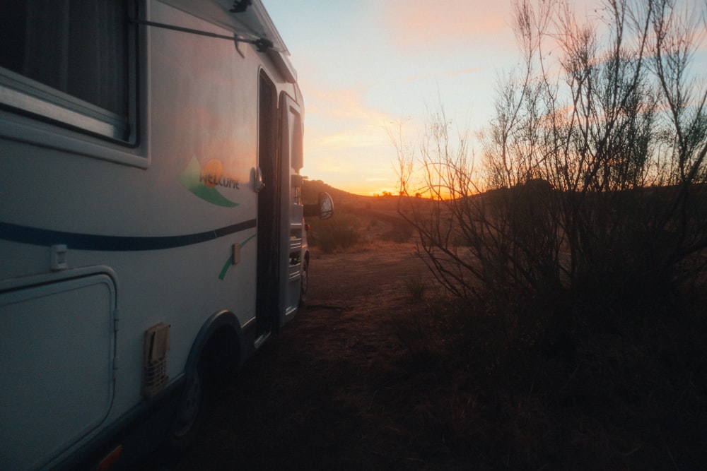 an rv parked in the desert at sunset