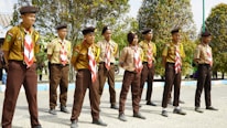 Children proudly wearing their Cub Scout uniforms during a group hike in the woods.
