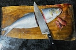 A whole uncleaned fish displayed on a cutting board.