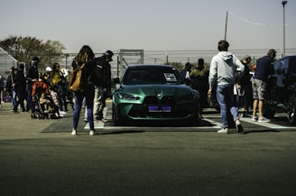 A group of diverse people discussing electric vehicles in a park setting.