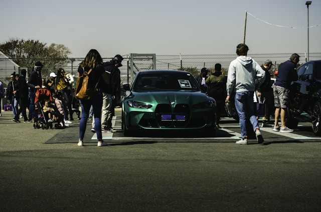 A diverse group of people discussing electric vehicles in a park setting.