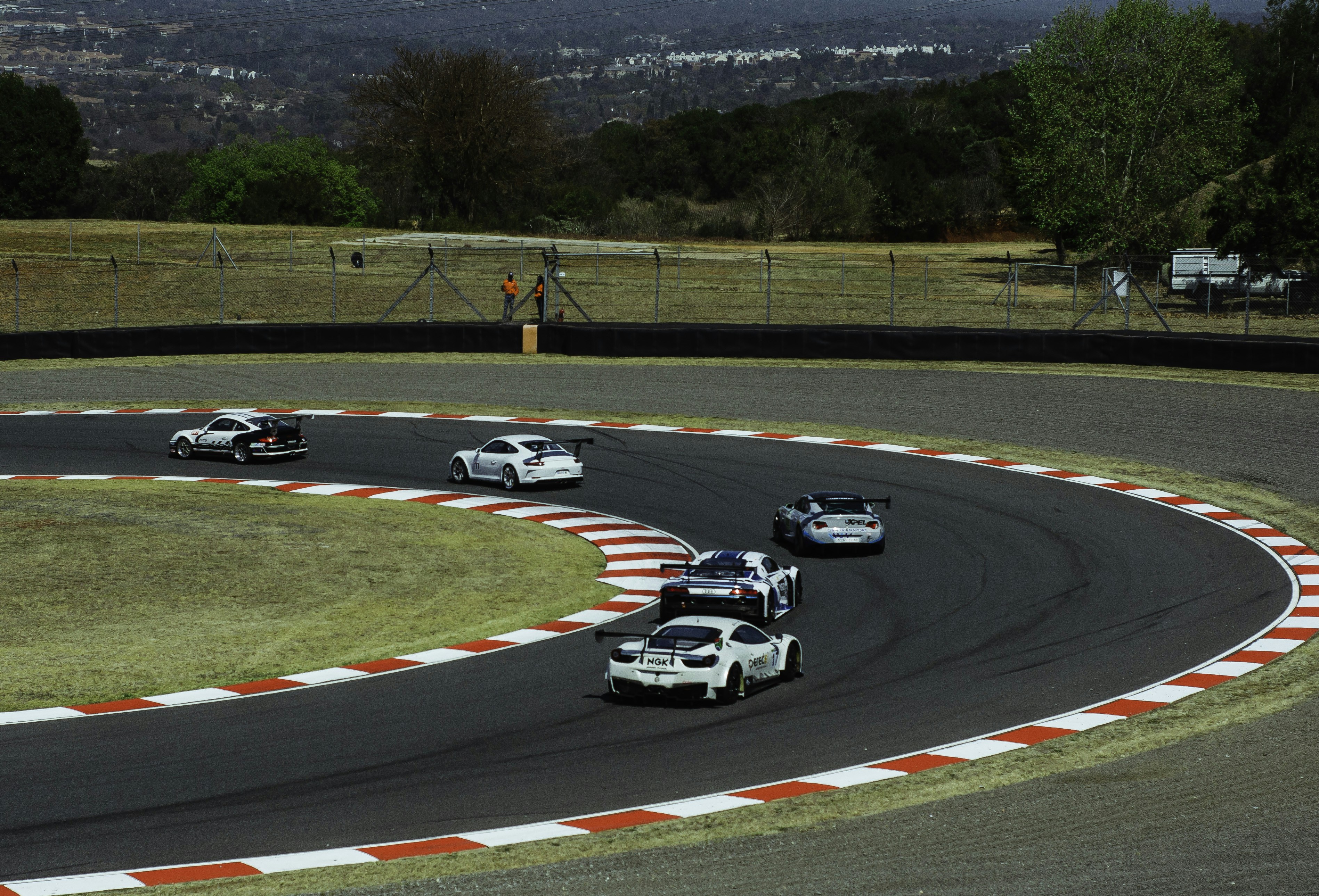 A group of cars driving down a race track photo – Free Wallpaper Image ...
