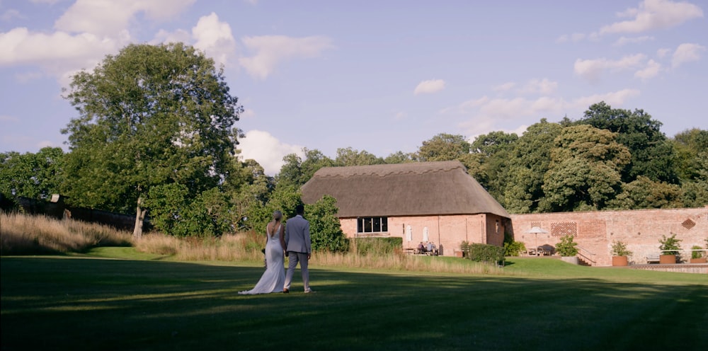 a bride and groom standing in front of a house