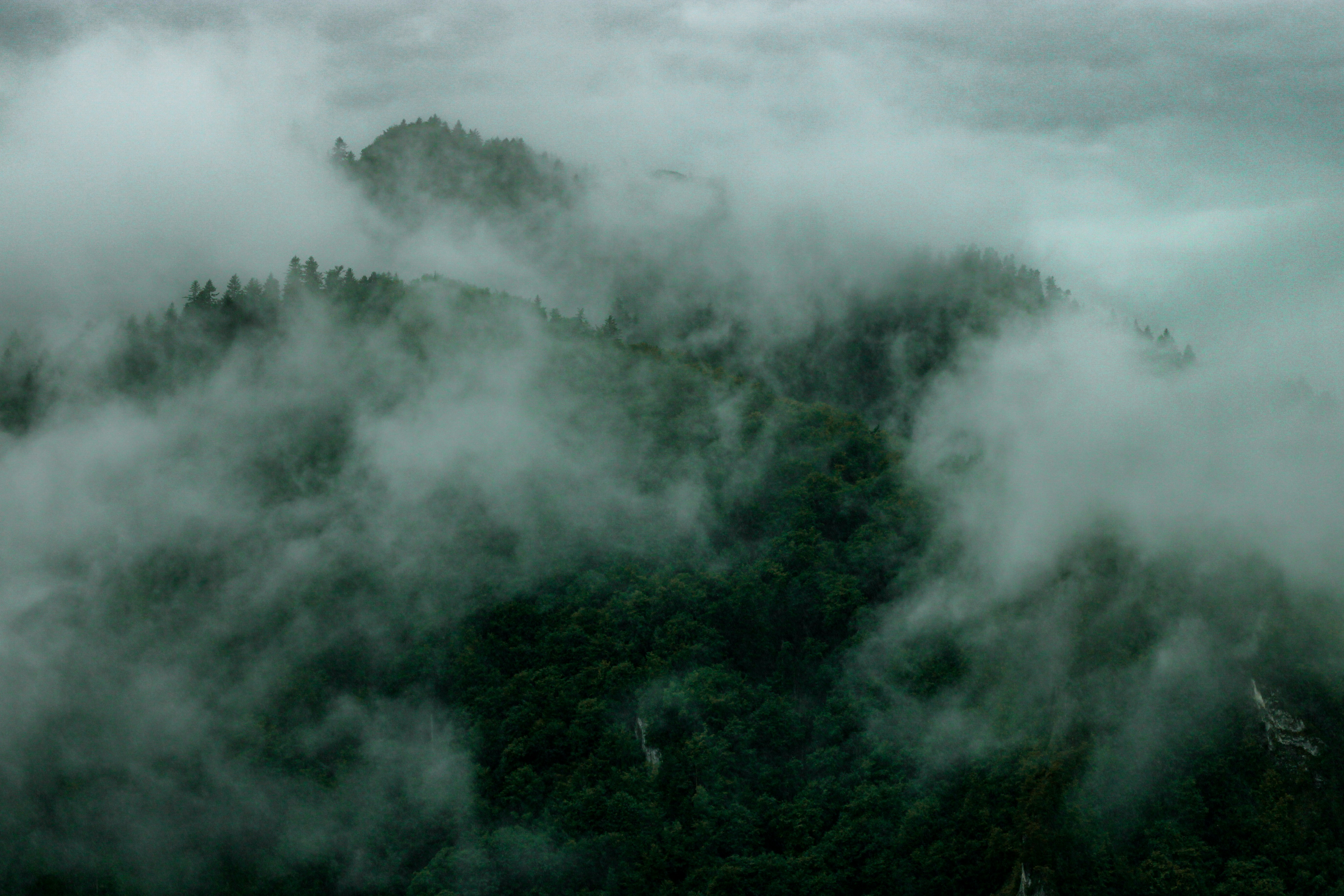a mountain covered in fog and low lying clouds, 