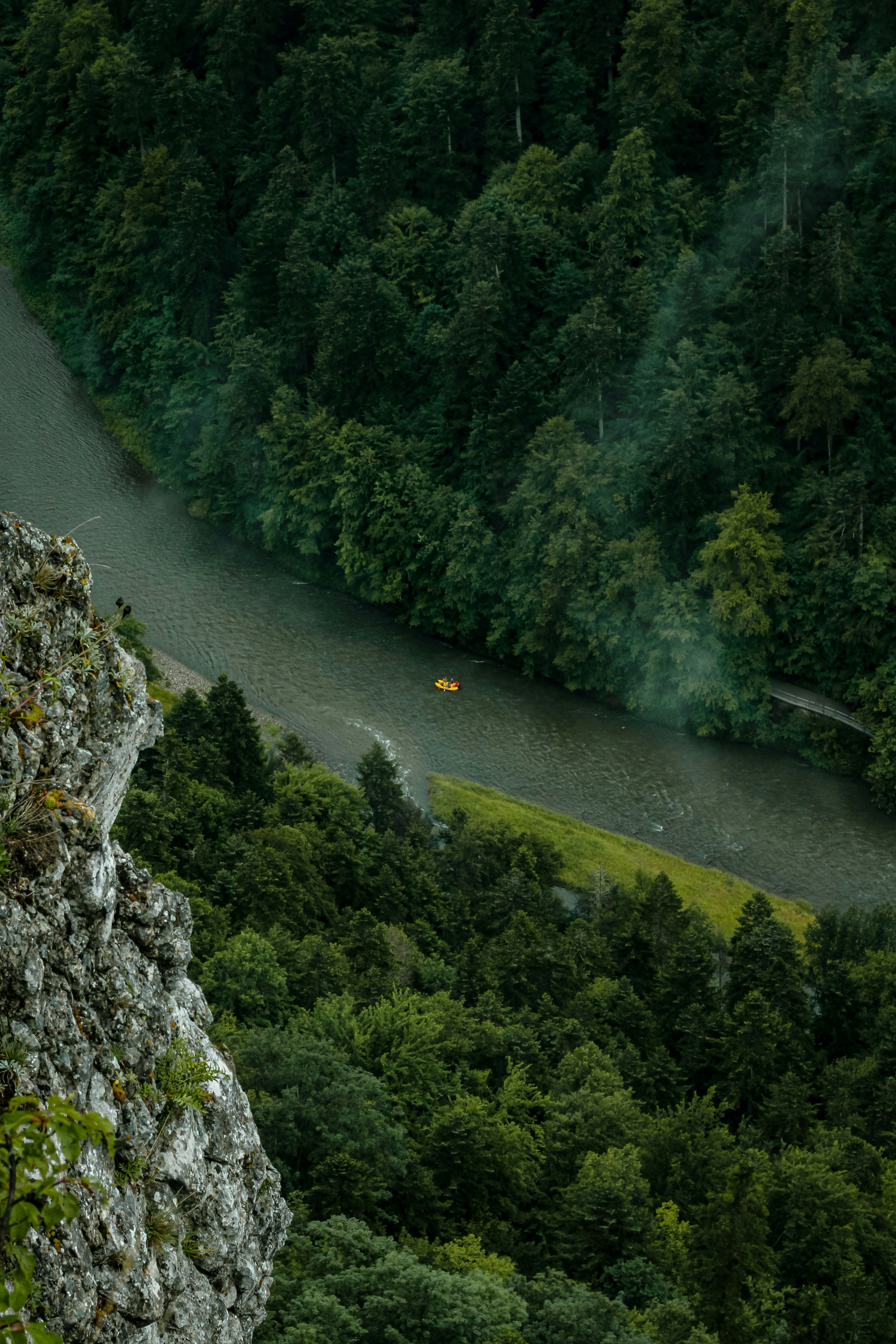 a man standing on top of a cliff next to a river