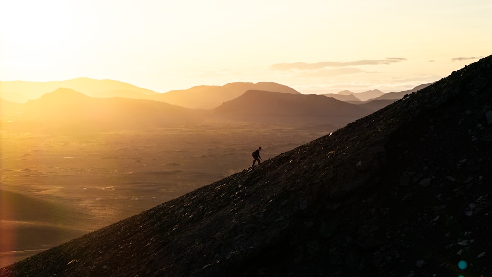 a person standing on top of a mountain at sunset