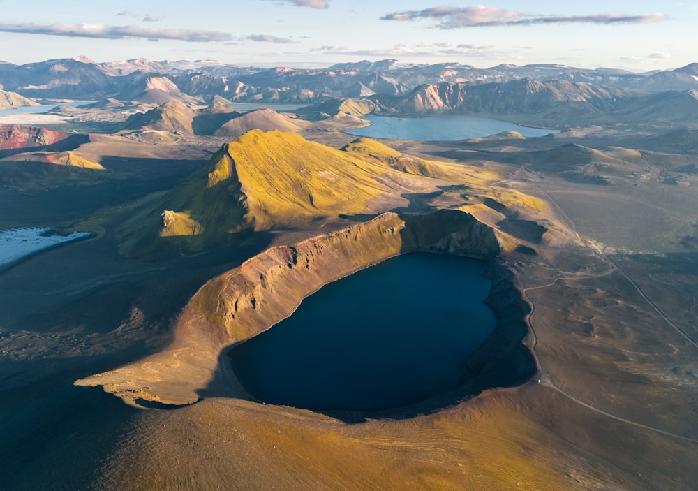 an aerial view of a lake surrounded by mountains