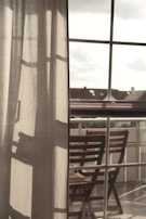 Golden silk curtains billowing lightly in a gentle breeze, framing a peaceful outdoor seating area.