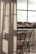 Curtains softly filter the light coming through a large window, with a clear view of an outdoor area featuring wooden chairs arranged on a balcony. The atmosphere suggests a peaceful and reflective moment, with shadows cast on the fabric adding depth.