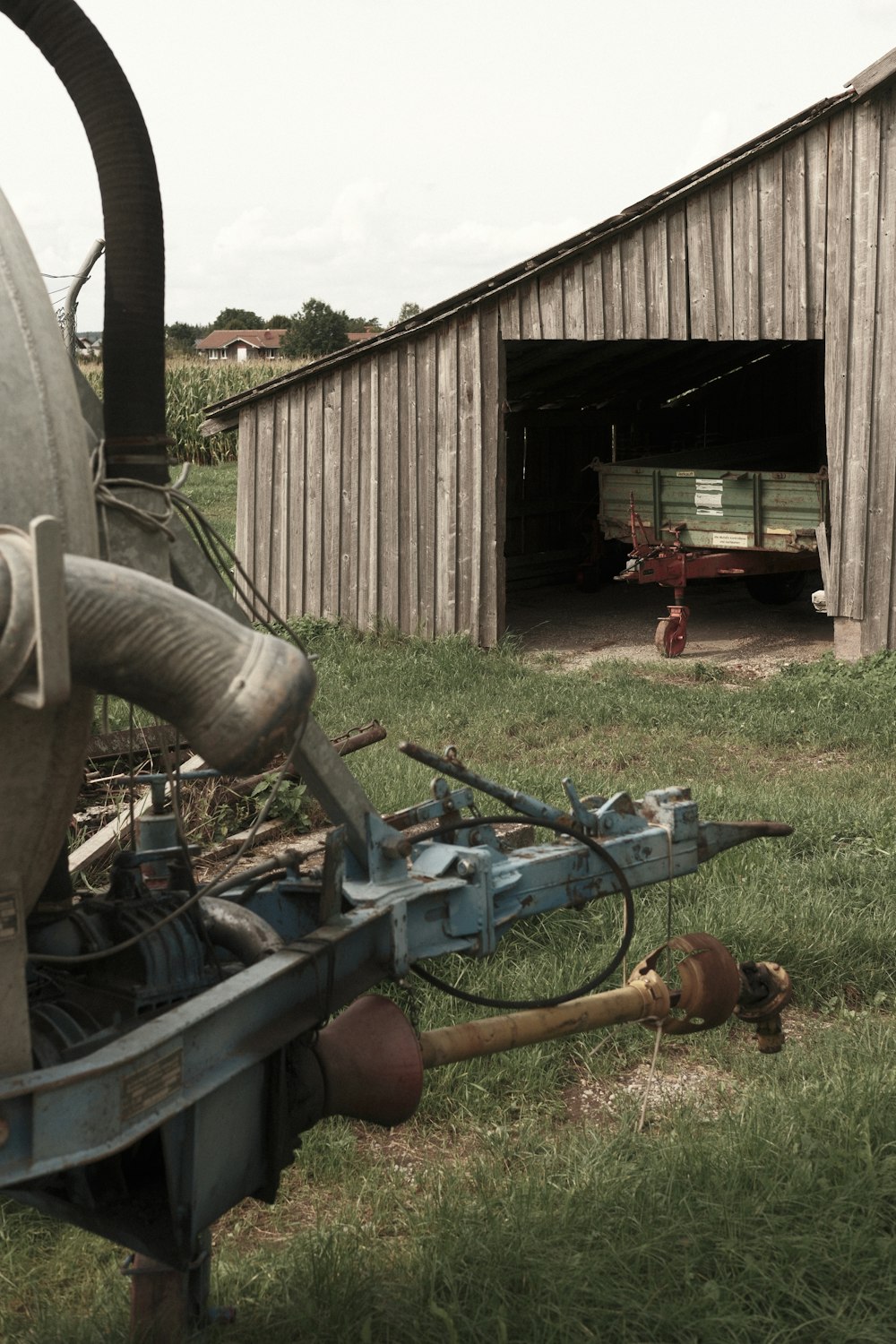 an old farm tractor sitting in a field next to a barn