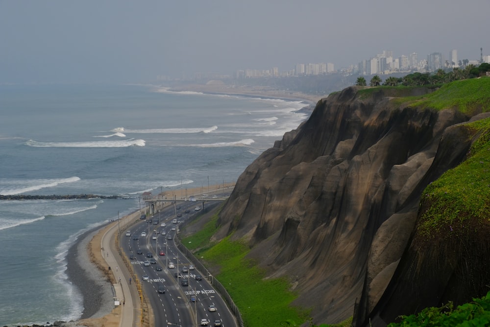 a view of the ocean and a highway with cars on it