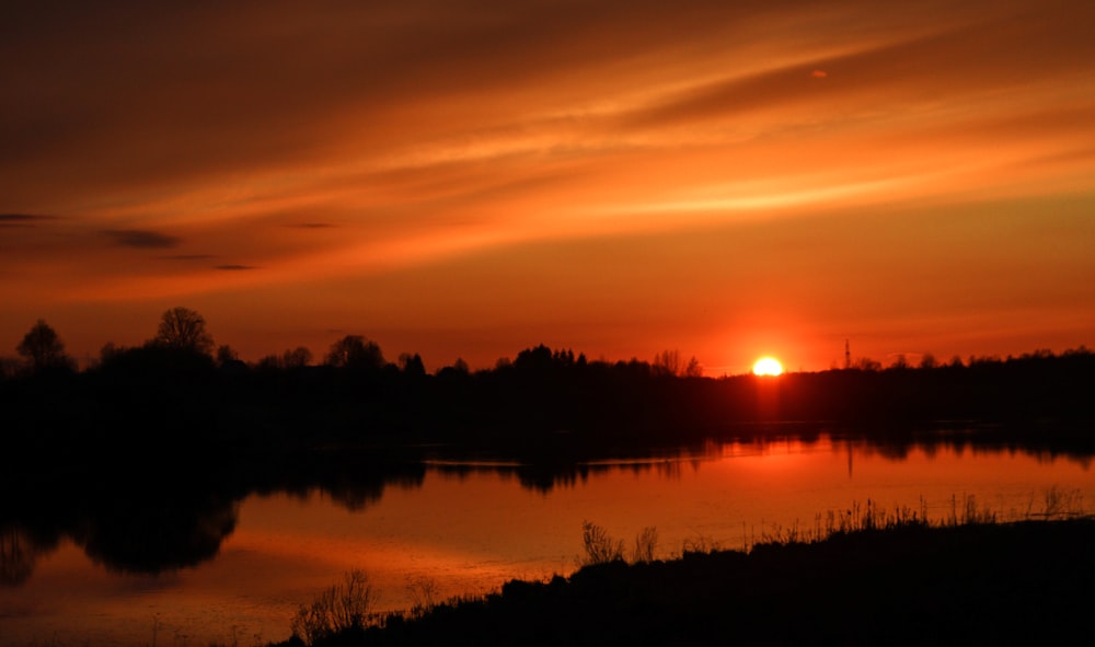 the sun is setting over a body of water