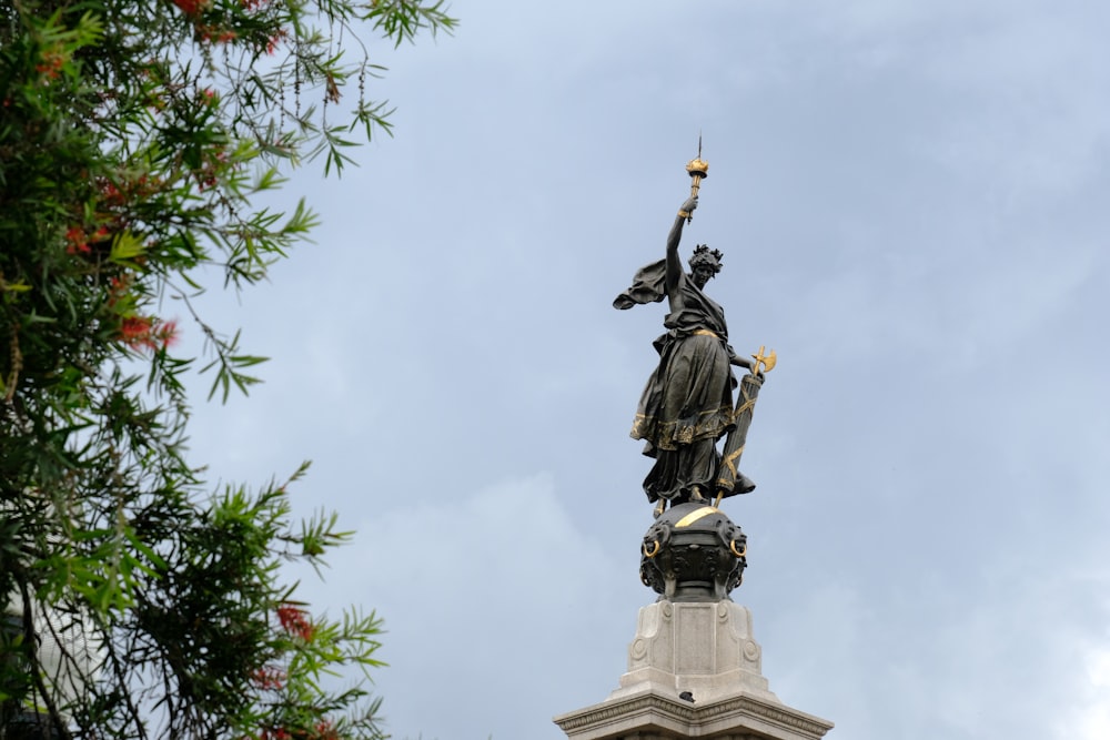 Una estatua en la parte superior de un edificio con un fondo de cielo