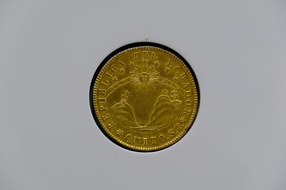 a close up of a gold coin on a white surface