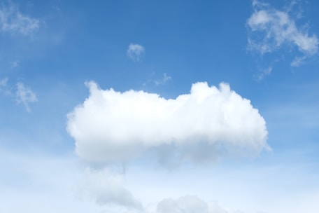 A bright white cloud floats in a clear blue sky.