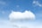 A bright white cloud floats in a clear blue sky.