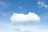 A bright white cloud floats in a clear blue sky.