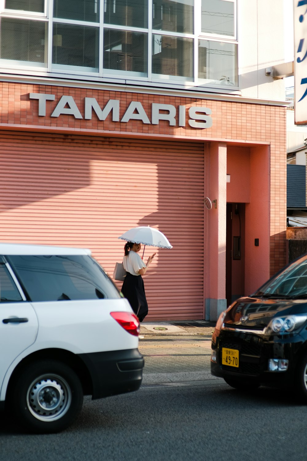 a woman with an umbrella standing in front of a building