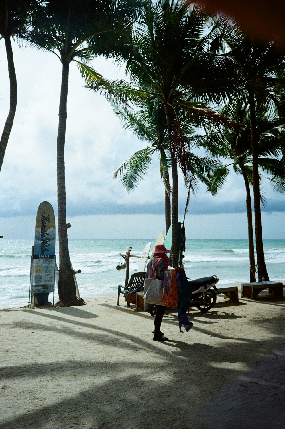 una persona che cammina su una spiaggia con una tavola da surf
