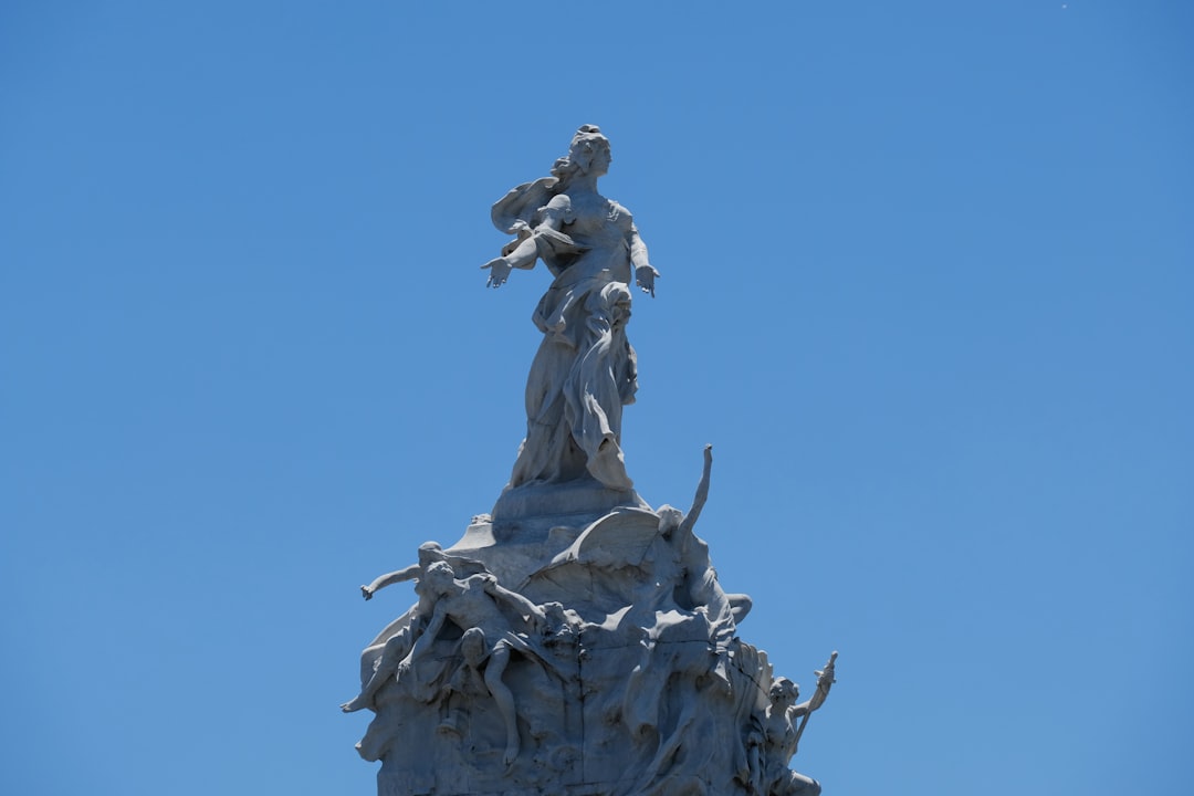 a statue on top of a building with a sky background,