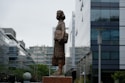 a statue of a woman standing in front of a building