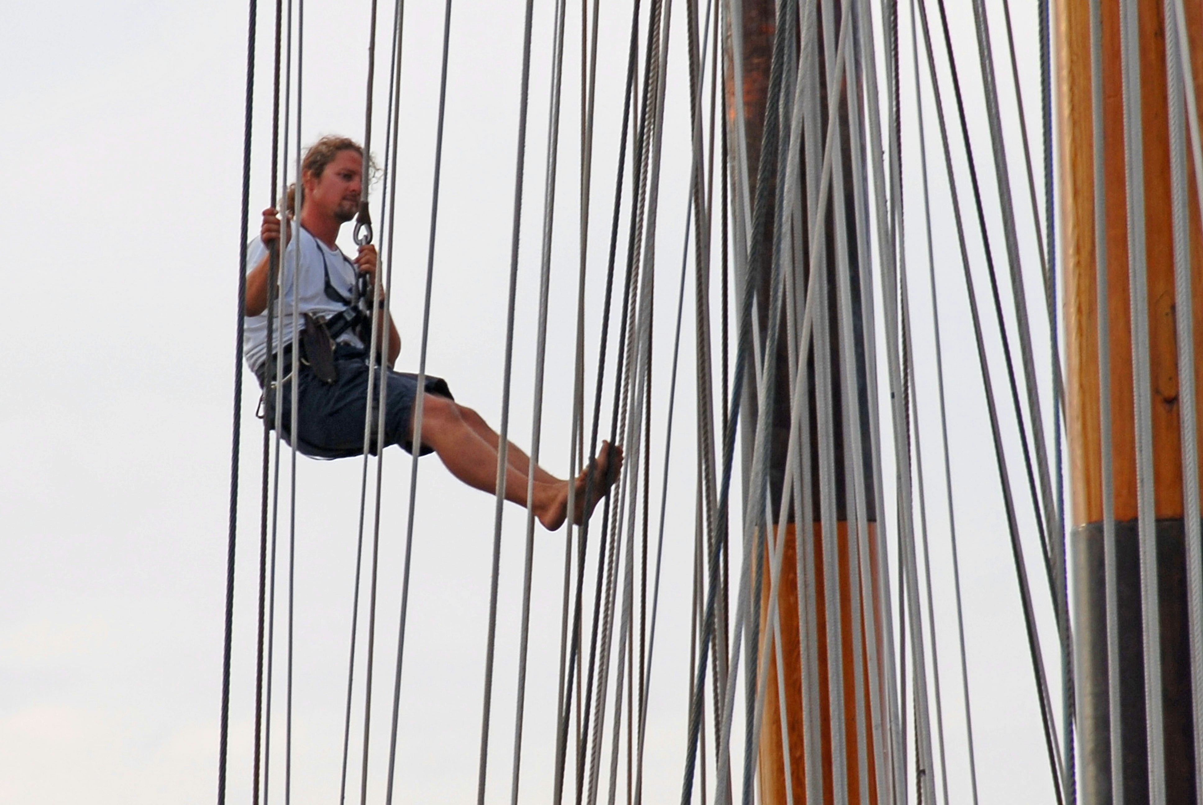 a woman climbing up the side of a tall ship