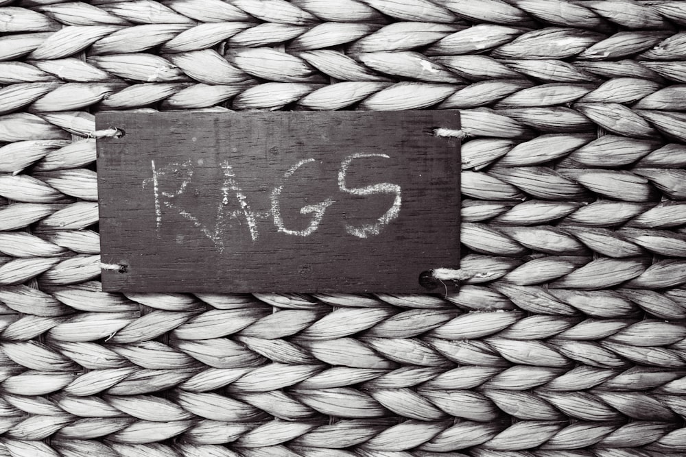 a black and white photo of a rope with a sign on it