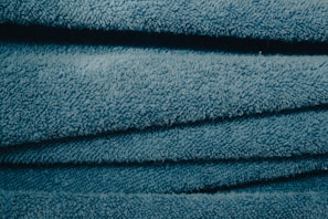 Close-up of a vibrant blue microfiber cloth folded neatly on a wooden table.