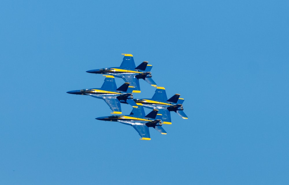 a group of fighter jets flying through a blue sky