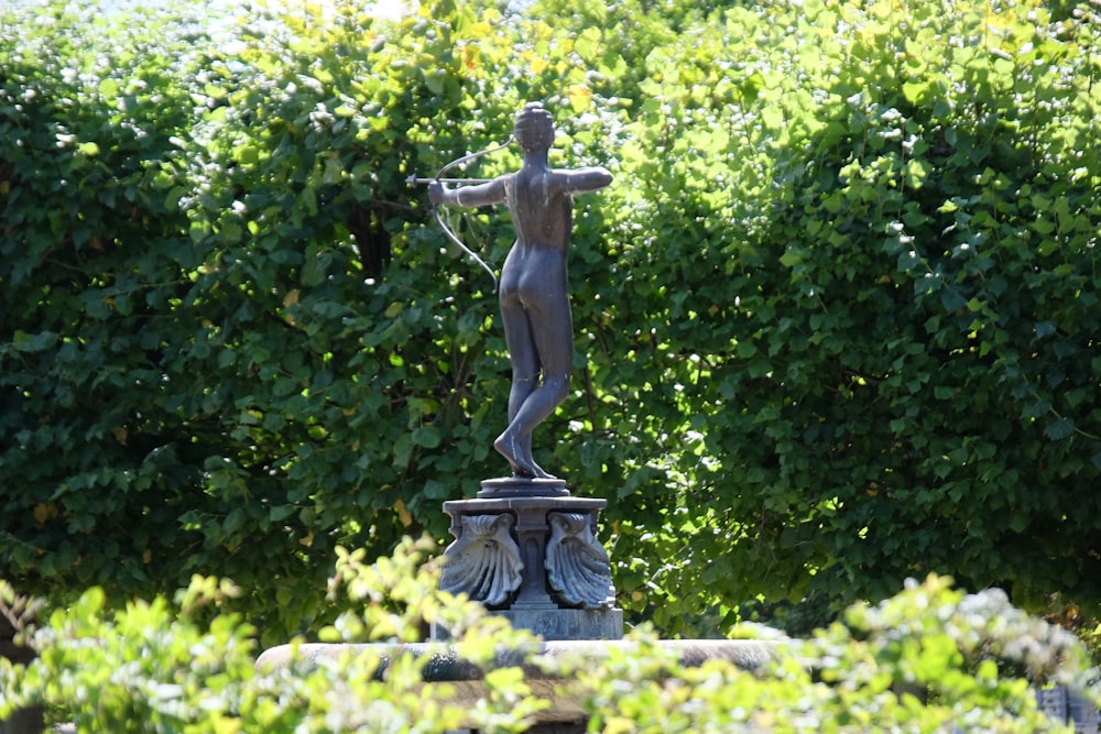 a statue of a woman holding a water hose