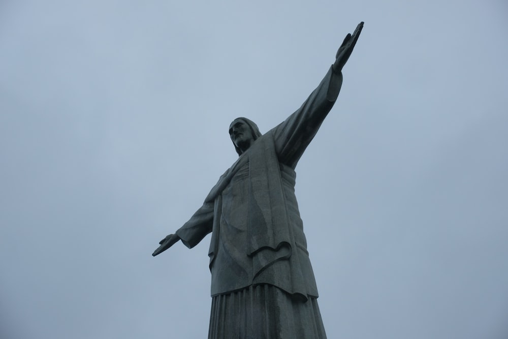 una statua di una persona con le braccia in aria