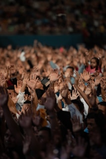 a crowd of people with their hands in the air